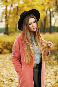 时尚的模特女士秋季肖像,街上摆姿势,休闲装,穿着牛仔衬衫,皮裙,老式明亮的外套黑色的帽子长发,街头风格图片