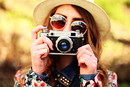户外夏季生活方式的肖像,美丽的轻女人城市玩得开心摄影师用时髦的眼镜帽子拍照片照片色调风格Instagram过滤器图片