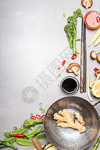 用炒锅筷子炒食材亚洲美食烹饪原料灰色石材背景,顶部视图图片