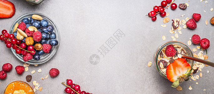 穆斯利,坚果浆果准备早餐格兰诺拉与新鲜浆果罐子石头背景,顶部视图,横幅健康食品清洁饮食理念背景图片