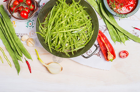 切好的青法豆烹饪菜与蔬菜烹饪原料白色木制背景,顶部视图,边界图片