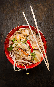 亚洲条与筷子,鸡肉芽黑暗的木制背景,顶部视图图片