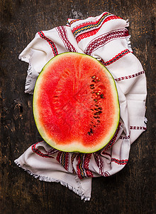 半成熟的红色西瓜与厨房毛巾乡村木制背景,顶部的景观图片