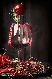 带节日诞装饰的红酒杯深色乡村木背景的迷迭香,侧视图片