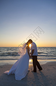 已婚夫妇,新娘新郎,日落日出的婚礼上美丽的热带海滩接吻图片