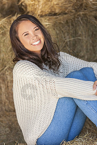 美丽快乐的亚洲欧亚青妇女女孩微笑着坐阳光下的干草堆谷仓图片