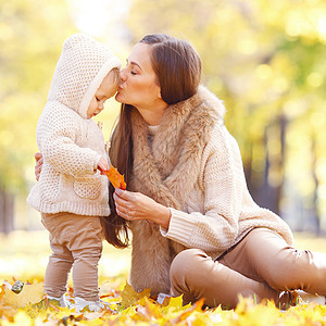 秋天公园的母亲孩子母亲孩子秋天的公园里玩得很开心图片