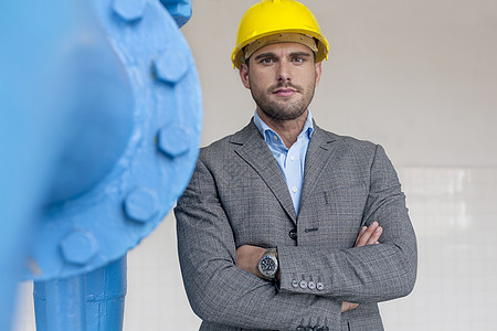 自信的轻男建筑师的肖像,站立的手臂交叉工业上图片