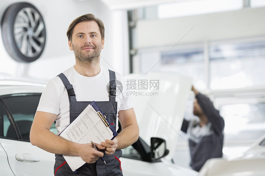汽车修理厂剪贴板自信男维修工程师的肖像