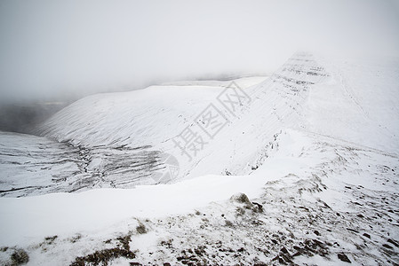 喜怒无常的低云冬季景观山上与地雪图片