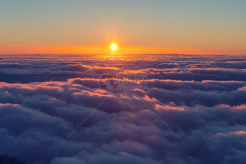 美丽的日落云层上方的山上图片