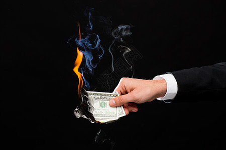 财务,人员,储蓄破产男手持燃烧美元现金的黑色背景图片