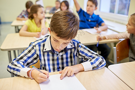 教育,小学,学人的群学校的孩子课堂上用钢笔笔记本写作测试图片