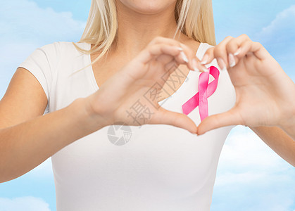 医疗保健,人民,慈善医学特写轻妇女的空白白色t恤与粉红色乳腺癌意识丝带心形蓝天背景图片