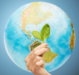 人,生态,环境,农业食品的密切妇女的手与绿色萌芽地球上的蓝色背景图片