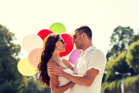 爱情,婚礼,夏天,约会人们的微笑的夫妇戴着太阳镜,公园里拥抱气球图片