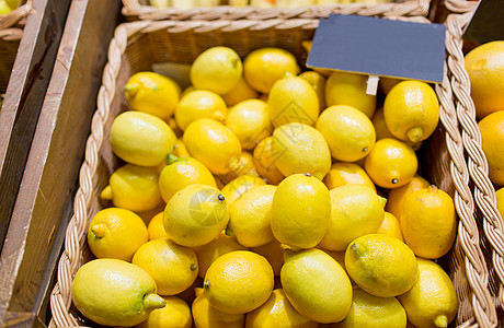 销售,购物,维生素C健康食品成熟柠檬篮子与铭牌杂货店市场图片