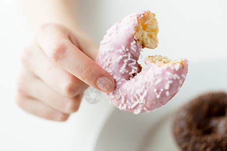 人,食物,垃圾食品饮食密切的女手咬釉甜甜圈图片