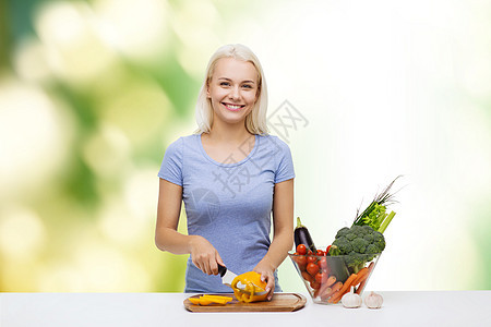 健康饮食,素食,烹饪,饮食人们的微笑的轻女人绿色的自然背景下切蔬菜图片