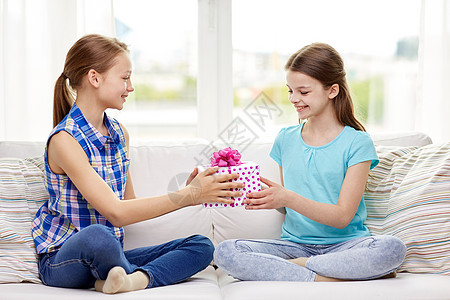 人,孩子,假期,朋友友谊的快乐的小女孩生日礼物坐家里的沙发上图片