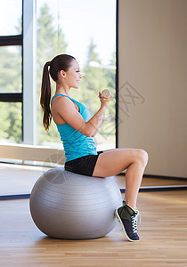 健身,运动,训练人的微笑的女人哑铃运动球弯曲肌肉健身房图片