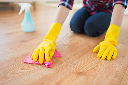 人,家务家务妇女橡胶手套与布洗涤剂喷雾清洁地板家里图片