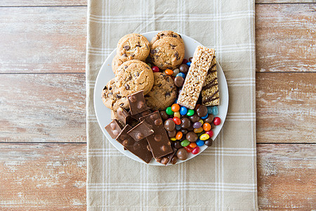 垃圾食品,糖果健康的饮食糖果,巧克力,穆斯利饼干盘子里图片