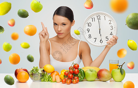 人们,饮食饮食的女人健康的食物着大钟,手指向上,警告灰色背景下的水果背景图片