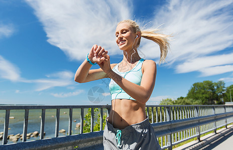 健身,运动,人,技术健康的生活方式微笑的轻妇女与心率手表耳机锻炼户外图片