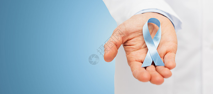近距离的男医生手握天蓝色前列腺癌意识丝带背景