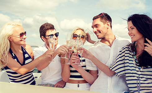 微笑的朋友带着杯香槟游艇上图片
