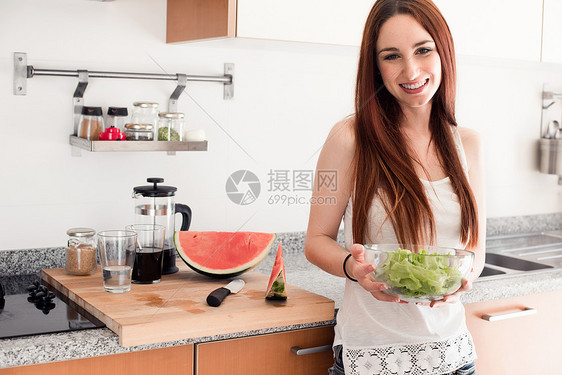 健康的女人在厨房准备新鲜沙拉图片