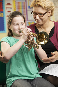 老师帮助学生音乐课上小号图片