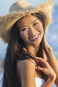 位美丽的中国亚洲轻妇女女孩海滩上穿着白色比基尼稻草牛仔帽的户外肖像图片