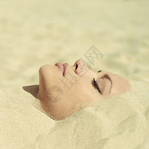 埋沙子里的美丽女士的艺术照片图片