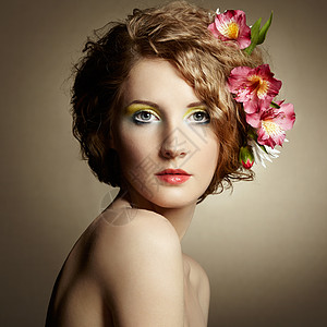 美丽的轻女人,头发上精致的花春天的照片图片