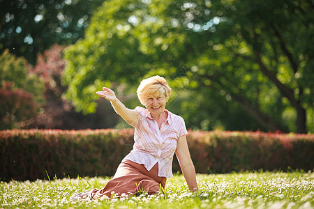 享受积极的情绪外向的老妇人躺草地上图片
