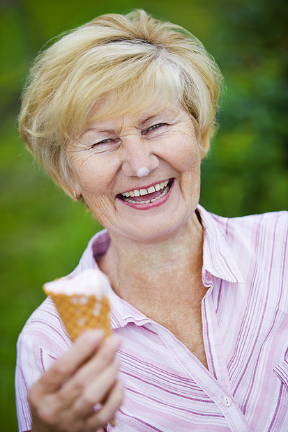 满足兴高采烈的老妇人着冰淇淋笑着图片