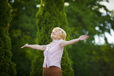 生活方式自由兴奋的退休老妇人伸出双臂背景图片