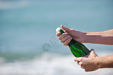 男子手打开瓶香槟酒葡萄酒饮料户外派庆祝活动图片