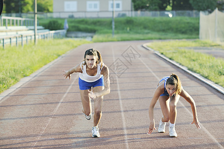 轻女孩晨跑运动赛道上的比赛图片