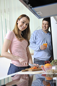 快乐的轻女人厨房里吃苹果其他食物蔬菜图片
