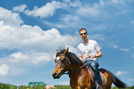 轻人骑马场动物,背景蓝天图片