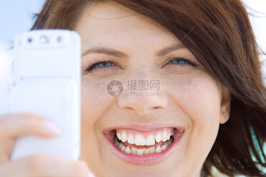 用手机相机的快乐女人的照片图片