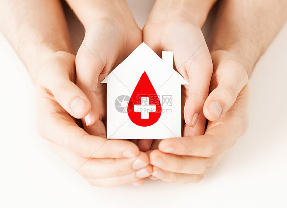 医疗保健医药献血男女手牵着手,着带红色供体标志的白纸屋图片