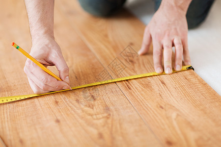 修理,建筑家庭男手测量木地板图片