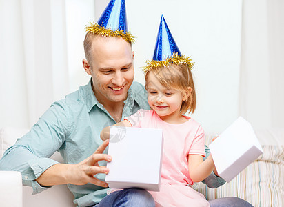 家庭,孩子,庆祝,节日,生日快乐的人的快乐的父亲女儿戴着蓝色的派帽礼品盒图片