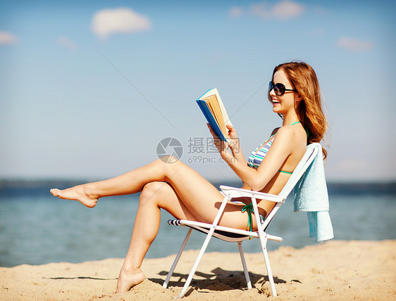 暑假假期女孩海滩椅子上看书图片