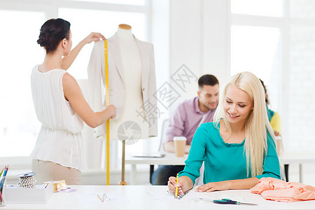 创业,教育,时尚办公室微笑师绘制草图测量夹克人体模型办公室图片