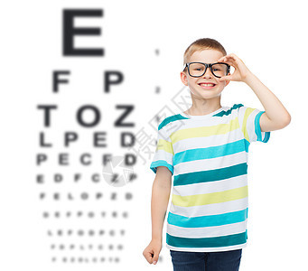 视觉,眼科儿童微笑的小男孩眼镜上的眼睛图表背景图片